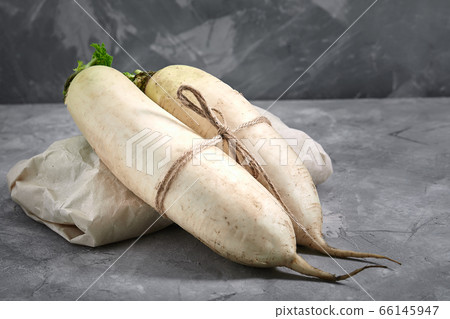 Daikon radish on concrete background with space for text. Natural products, gray background 66145947
