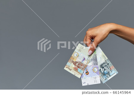 Beautiful female hands hold the Catalan rial on a gray background. Copy space, gray background 66145964
