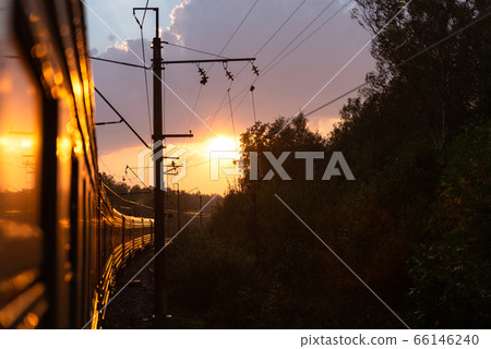 An electric locomotive. The train takes me into the sunset. Railway tracks curve. An electric locomotive. The train takes me into the sunset. Railway tracks curve. 66146240