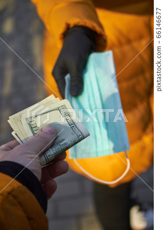 Hands exchange 100 dollar bills for a surgical 66146677