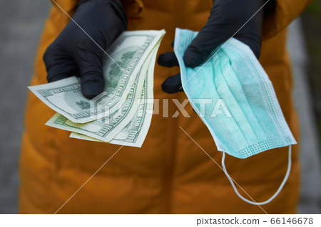 Hands holds 100 dollar bills for a surgical face 66146678