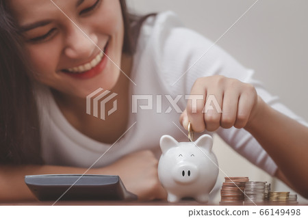 Female hand putting money into piggy bank for saving money, save money and management financial concept. Female hand putting money into piggy bank for saving money, save money and management financial concept. 66149498