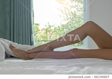 Perfect legs on bed with bent knees side view. Perfect legs on bed with bent knees side view. 66149807