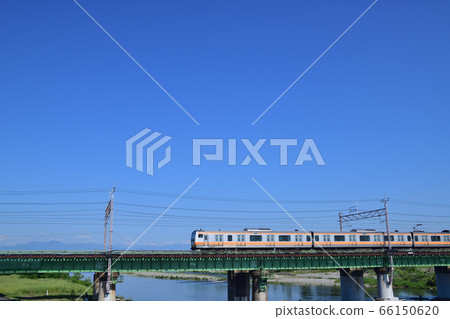 Chuo Line E233 series trains that cross the Tama River bridge against the backdrop of the clear sky and the mountains of Okutama Chuo Line E233 series trains that cross the Tama River bridge against the backdrop of the clear sky and the mountains of Okutama 66150620
