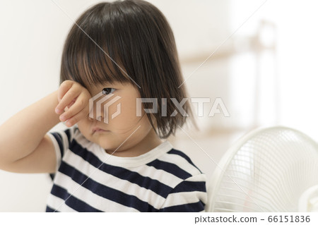 A girl who is tired of playing and wants to sleep and rubs her eyes 66151836