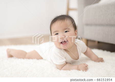 一個8個月大的嬰兒在家裡的客廳裡徒步旅行 一個8個月大的嬰兒在家裡的客廳裡徒步旅行 66151954