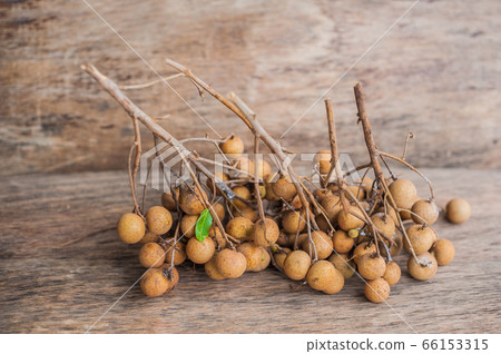 Longan Fresh Dimocarpus longan. A bunch of Longan and Peel show the white meat with black seed was placed on a wooden background Longan Fresh Dimocarpus longan. A bunch of Longan and Peel show the white meat with black seed was placed on a wooden background 66153315