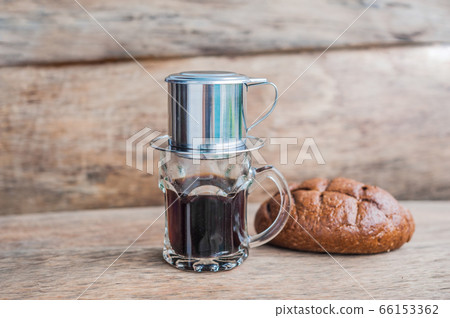 'Phin' traditional Vietnamese coffee maker, place on the top of glass, add ground coffee then pour hot water and wait until the coffee dripping into the glass. 'Phin' traditional Vietnamese coffee maker, place on the top of glass, add ground coffee then pour hot water and wait until the coffee dripping into the glass. 66153362