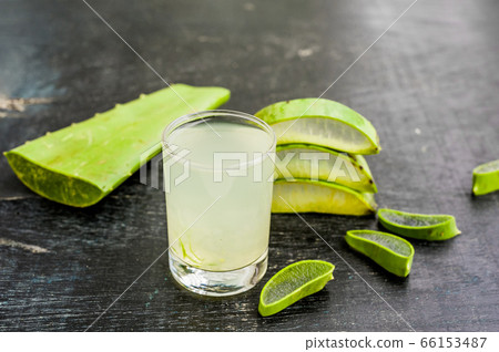 Aloe vera pieces and aloe gel in the glass on an old dark wood background Organic cosmetics concept 66153487