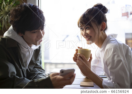 Men and women relaxing in a cafe Men and women relaxing in a cafe 66156924