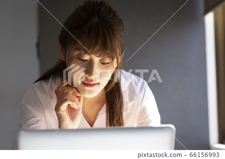 A woman looking at a computer A woman looking at a computer 66156993