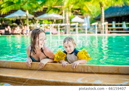 Young cheerful mother and son in a swimming pool Young cheerful mother and son in a swimming pool 66159407