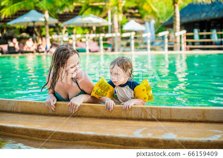 Young cheerful mother and son in a swimming pool 66159409