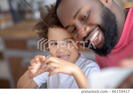 Sweet little girl showing love sign while her father making selfie 66159417