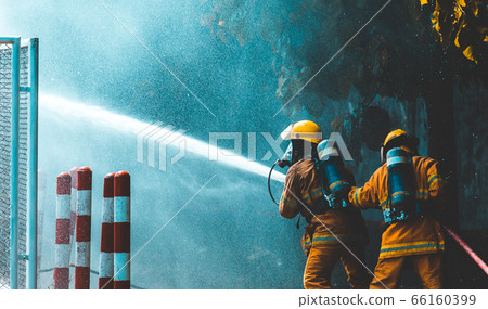 firefighters spray water to wildfire 66160399
