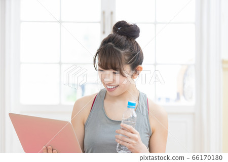 Woman looking at a laptop wearing training wear 66170180