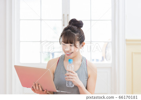 Woman looking at a laptop wearing training wear 66170181