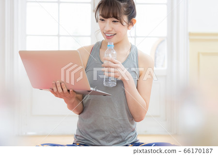 Woman looking at a laptop wearing training wear 66170187
