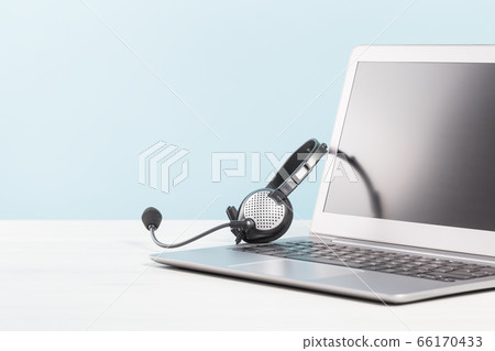 Laptop with headphones on white desk 66170433