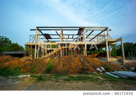 Perspective of house structure under construction at site with blue sky background Perspective of house structure under construction at site with blue sky background 66172939