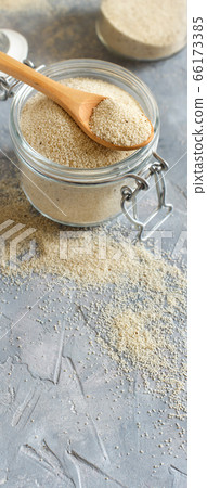 Raw uncooked fonio seeds in a glass jar with a Raw uncooked fonio seeds in a glass jar with a 66173385