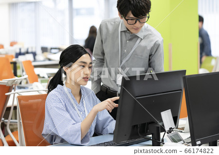 年輕的上班族，看著電腦顯示器的業務場景圖像 66174822