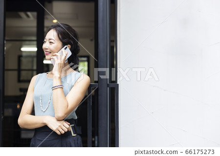 A woman who speaks with a smartphone 66175273