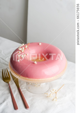 Holiday homemade glazed strawberry cake on a glass plate decorated eco plant on a cloth table against light grey wall. 66175656