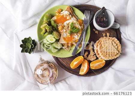Fried eggs with toasts and tea in bed Fried eggs with toasts and tea in bed 66176123