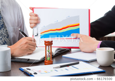 Two Asian businessmen discussing the sale volume and pointing the main item in graph chart 66176500