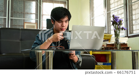 Smart man in denim shirt drinking a coffee while working. Smart man in denim shirt drinking a coffee while working. 66176751