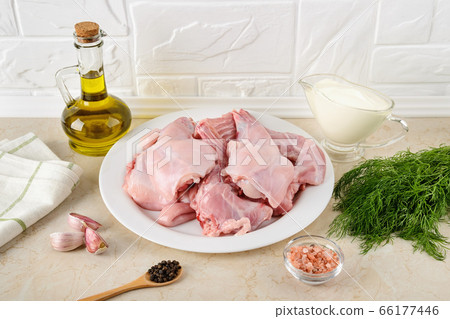 Pieces of raw rabbit meat, sour cream, garlic, pepper, salt, olive oil and bunch of dill. 66177446