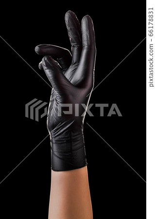 Hand in black gloves taking or showing something isolated on black background Hand in black gloves taking or showing something isolated on black background 66178831