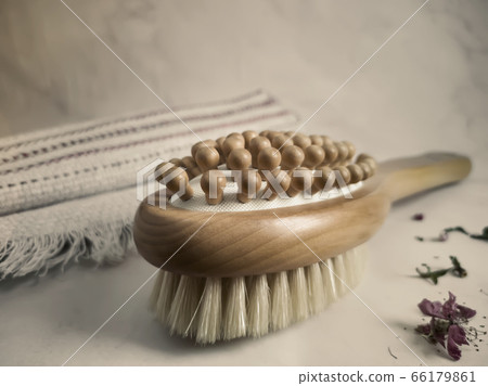 Wooden massage anti-cellulite brush on a linen towel close-up. Wooden massage anti-cellulite brush on a linen towel close-up. 66179861