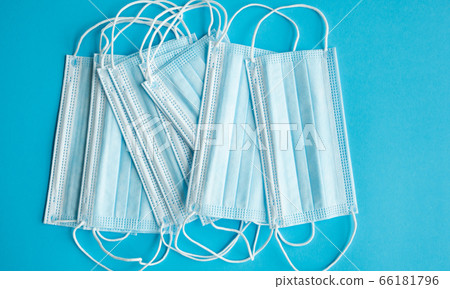 Medical protective masks on a blue background. Disposable 3-ply medical mask to cover the mouth and nose to prevent coronavirus. Coronavirus quarantine. Antivirus medical mask for protection covid-19. Medical protective masks on a blue background. Disposable 3-ply medical mask to cover the mouth and nose to prevent coronavirus. Coronavirus quarantine. Antivirus medical mask for protection covid-19. 66181796