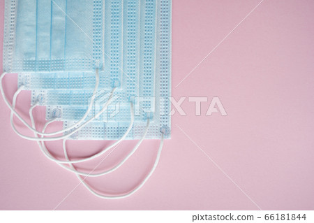 Medical protective masks on a pink background. Disposable 3-ply medical mask to cover the mouth and nose to prevent coronavirus. Coronavirus quarantine. Antivirus medical mask for protection covid-19. 66181844