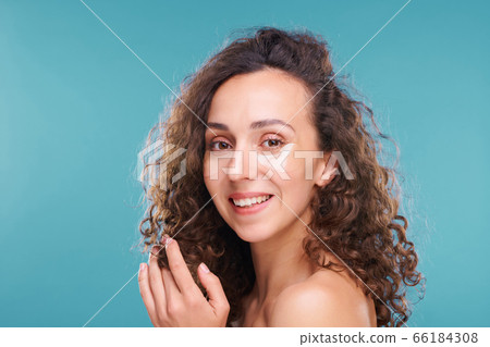 Young cheerful woman with beautiful thick curly hair having beauty procedure Young cheerful woman with beautiful thick curly hair having beauty procedure 66184308