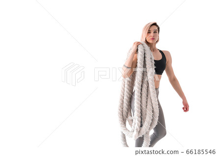 Woman doing exercises with battle rope. 66185546
