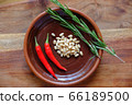 Fresh rosemary, hot red pepper and pine nuts on a clay plate on a wooden background with crystals of coarse white salt. The concept of a delicious and healthy diet. 66189500