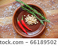 Fresh rosemary, hot red pepper and pine nuts on a clay plate on a wooden background with crystals of coarse white salt. The concept of a delicious and healthy diet. 66189502