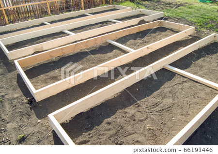 Wooden formwork from new boards for vegetable beds in the garden, preparation and construction, carpentry Wooden formwork from new boards for vegetable beds in the garden, preparation and construction, carpentry 66191446