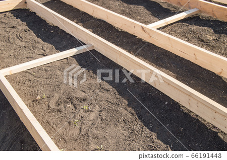 Wooden formwork from new boards for vegetable beds in the garden, preparation and construction, carpentry Wooden formwork from new boards for vegetable beds in the garden, preparation and construction, carpentry 66191448