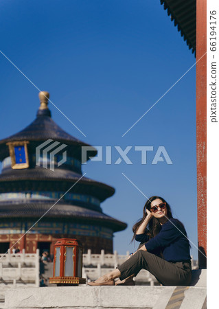brunette girl sitting on the steps by temple of heven in China brunette girl sitting on the steps by temple of heven in China 66194176