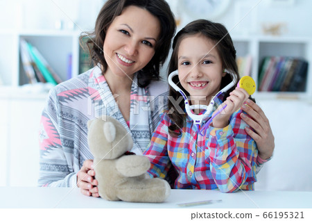 Mother with her little daughter playing nurse Mother with her little daughter playing nurse 66195321