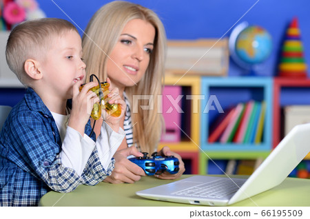 Mother and son playing computer game with laptop Mother and son playing computer game with laptop 66195509