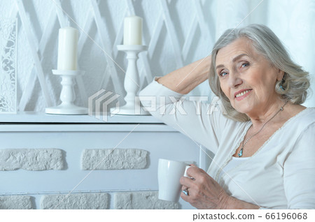 Portrait of beautiful smiling senior woman drinking tea Portrait of beautiful smiling senior woman drinking tea 66196068