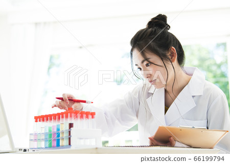 Young woman in white coat studying Young woman in white coat studying 66199794
