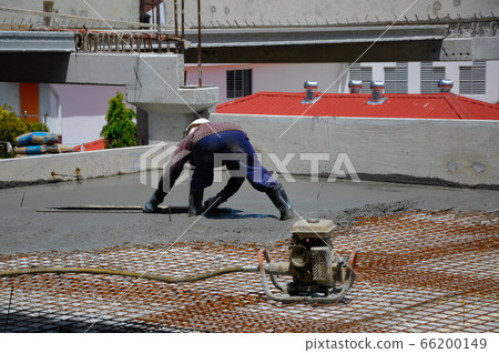 MALACCA, MALAYSIA -JUNE 17, 2016: Construction workers levelling the pouring wet concrete on the floor at the construction site. MALACCA, MALAYSIA -JUNE 17, 2016: Construction workers levelling the pouring wet concrete on the floor at the construction site. 66200149