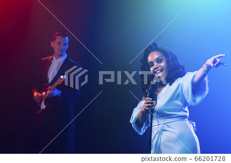 A jazz singer performs on stage. Afro. 66201728
