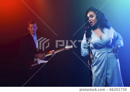 A jazz singer performs on stage. Afro. 66201730